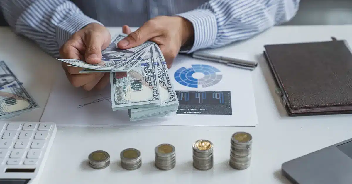 an HVAC business owner counts money and looks at business growth charts
