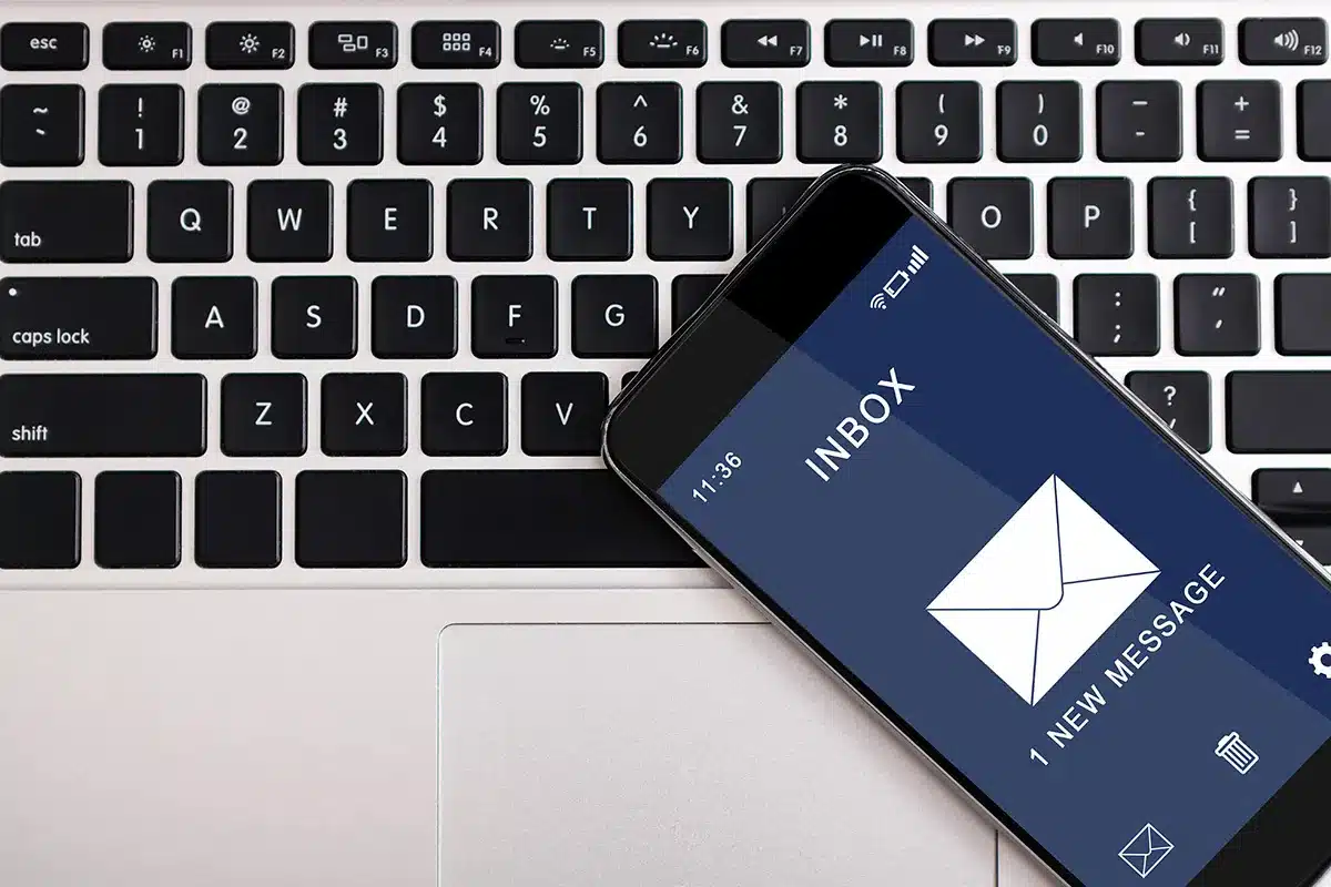 A phone shows an email notification from the HVAC playbook newsletter