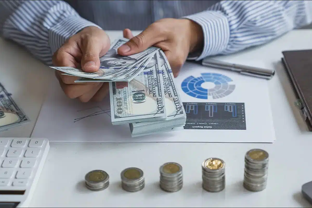 An HVAC business owner counts money from his growing HVAC business